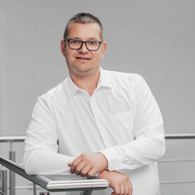 Andreas Düren, Montageleitung / Bauleitung bei BRAUN Keller lehnt an Treppengeländer